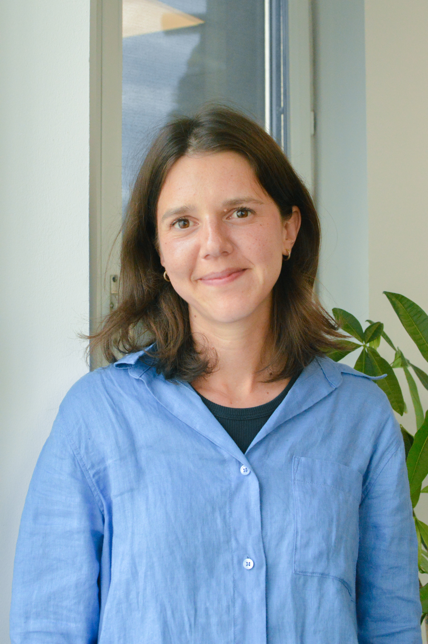 Ela Suleymangil_FCI_Agneskena Woman with shoulder-length brown hair wears a blue shirt.