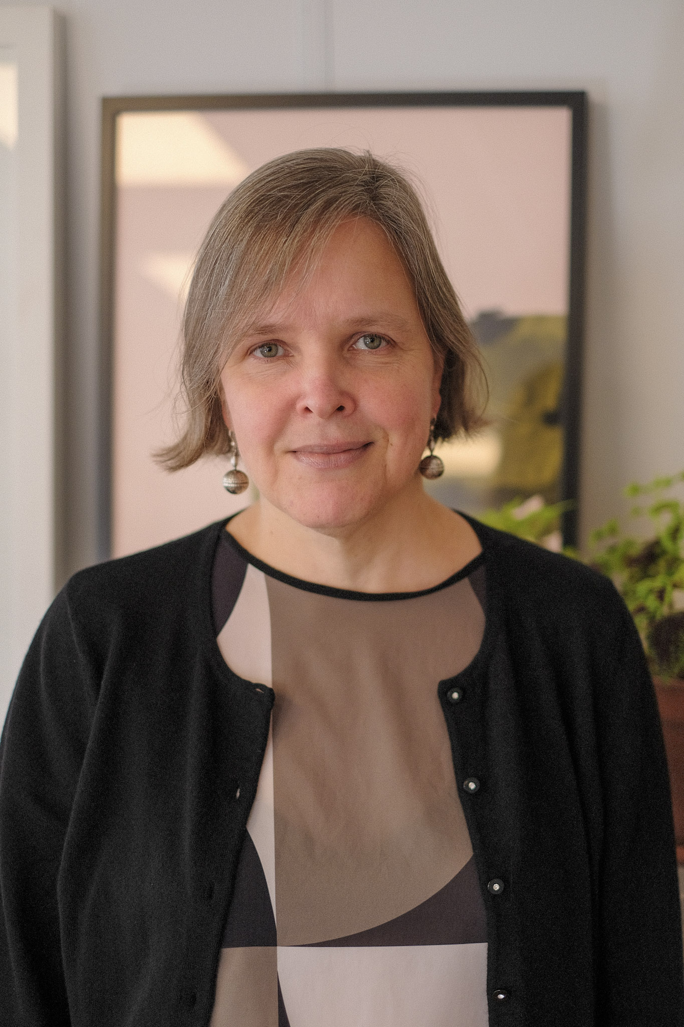 Eeva-Maria Viitanen_FCI_Agneskena A woman looks directly at the camera. She a bob and is wearing a black cardigan over a brown blouse.