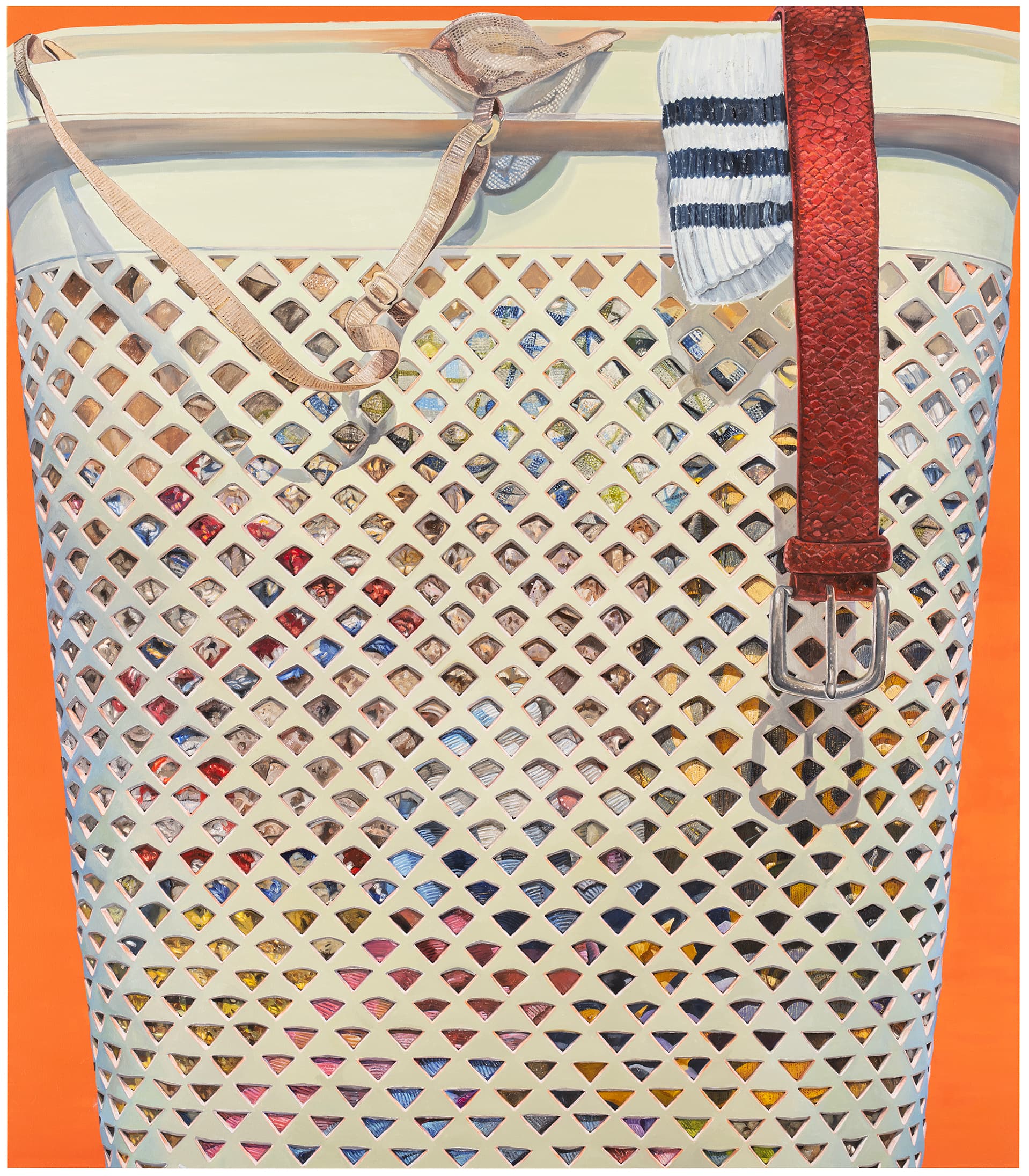 A close up of a basket bag or laundry basked. A belt and sock can be seen hanging out over the top.